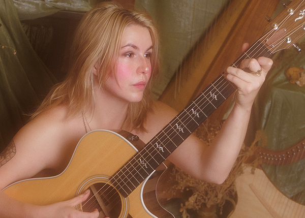 Kimawa of Jude Brothers: a young woman holding a guitar, with bare shoulders