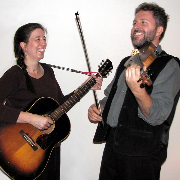 Box and String with their instruments: Sara on guitar, Bill on fiddle