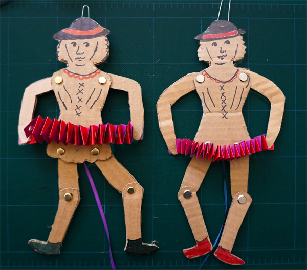Jumping Jills: little people made from cardboard cutouts, with moving joints held together with brads