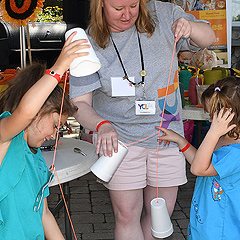 A woman helps two little girls with an activity