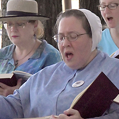 Three women participate in a Shape Note Singing session