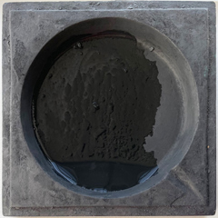 The round well of Diana’s ink stone, with a wet patch of ink covering about 90% of the well.