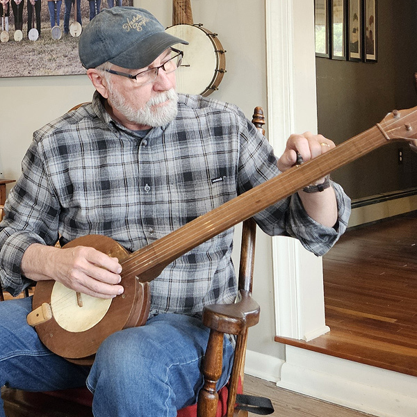 Glenn Carson tuning a fretless gourd banjo