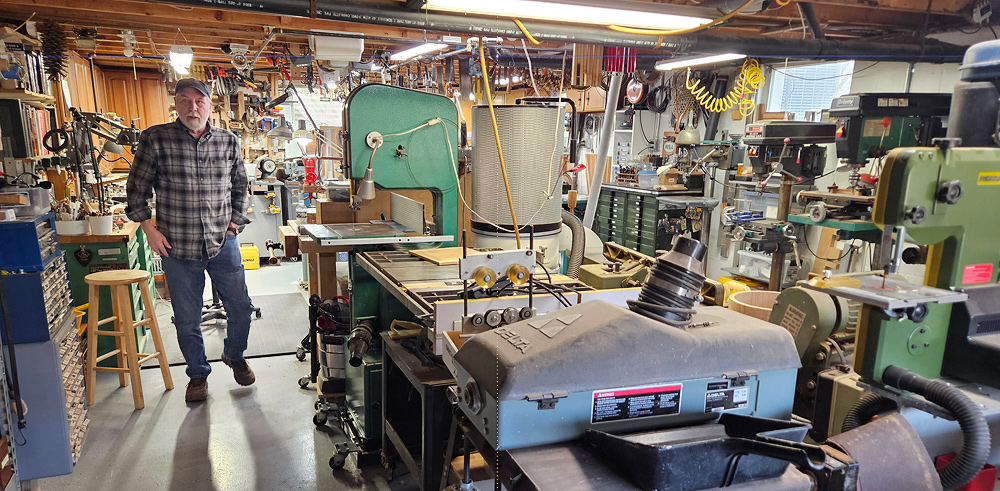 Glenn’s workshop is a large unfinished basement packed with tools and equipment. In the center of the room are large power tools including a bandsaw, two drill presses, a belt sander and a table saw. Around the edges of the room, separated by a narrow walkway, are toolboxes, parts cabinets and a workbench.