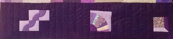 A close-up of the border of the purple quilt, showing three traditional pattern blocks that remind Sharon of her grandmother’s work.  From left: (1) Drunkard’s Path: each square features a quarter-circle of dark appliquéd on a square of light -- (2) Grandmother’s Fan: a square with a dark quarter-circle in one corner and ’rays’ of different prints making a larger quarter-circle) -- (3) Shadow Box: a square of patterned calico 2/3 the size of the overall block, positioned in upper left; darker purple to the right and lighter lavender at bottom, with a diagonal seam where they join so it looks like you’re looking into a box