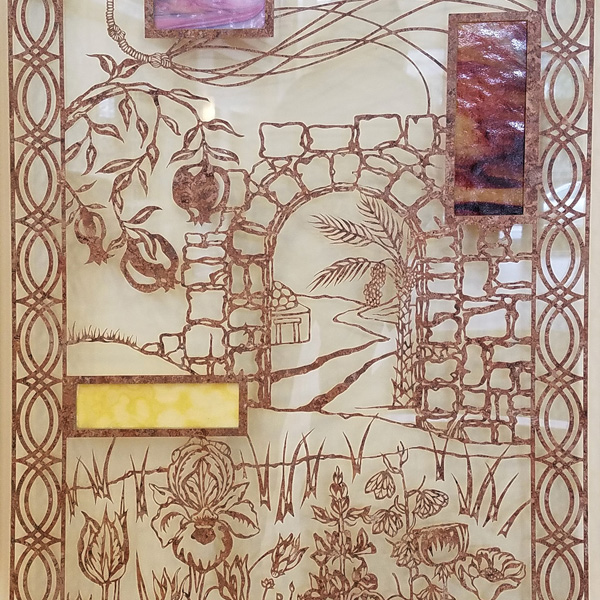 A traditional paper-cut creation, executed in brownish marbled film, sandwiched in thick acrylic and suspended in front of a lighter colored wall. The design shows a stone archway, with various flowers in the foreground, and an abstract border on the left and right edges.  Looking through the archway, one sees a date palm, a roadway, and a building suggestive of Israel.  The panel also incorporates two rectangles of opaque opalescent art glass in shades of brown.